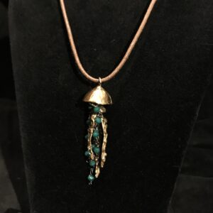 pendente in bronzo con medusa e cristalli color smeraldo, realizzato a mano con tecnica a cera persa
